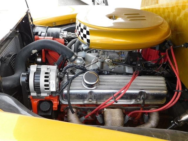 Classic Chevy truck engine bay with red accents and checkered air filter cover