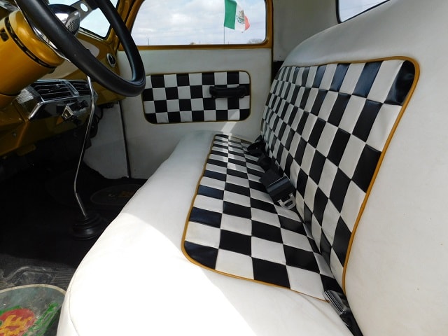 Classic truck interior with black and white checkered upholstery and gold trim